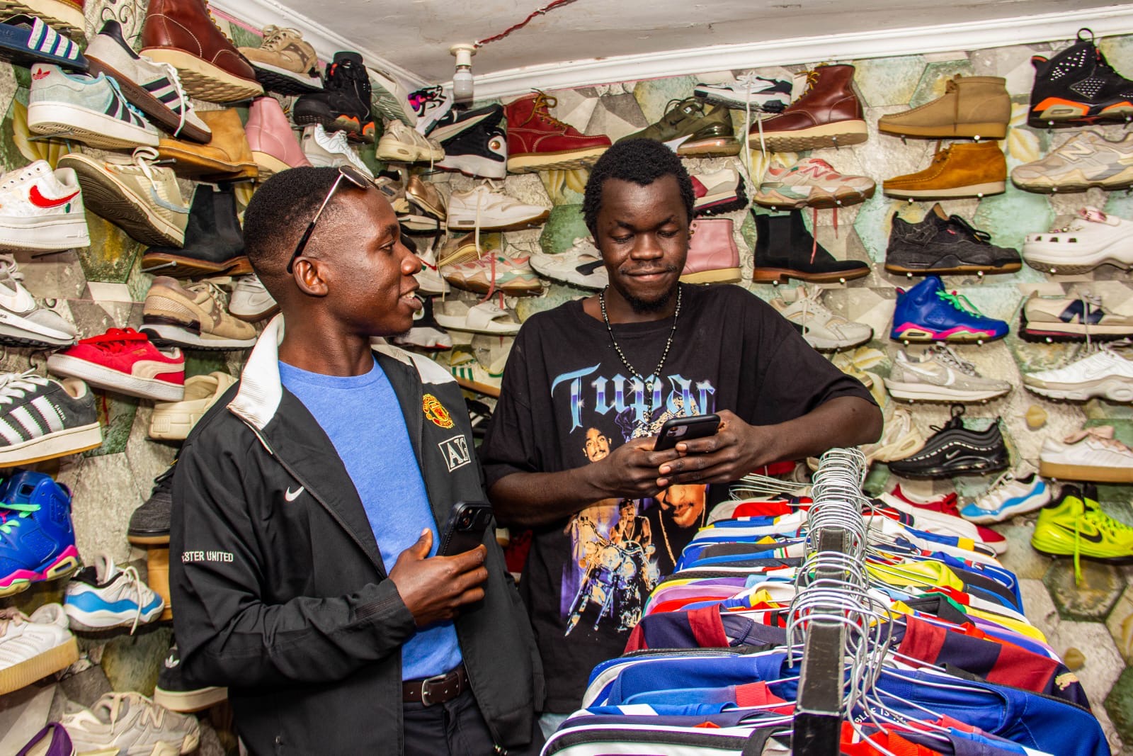 Paying in Bitcoin at a Kibera boutique with a wall of sneakers and a rail of vintage jackets