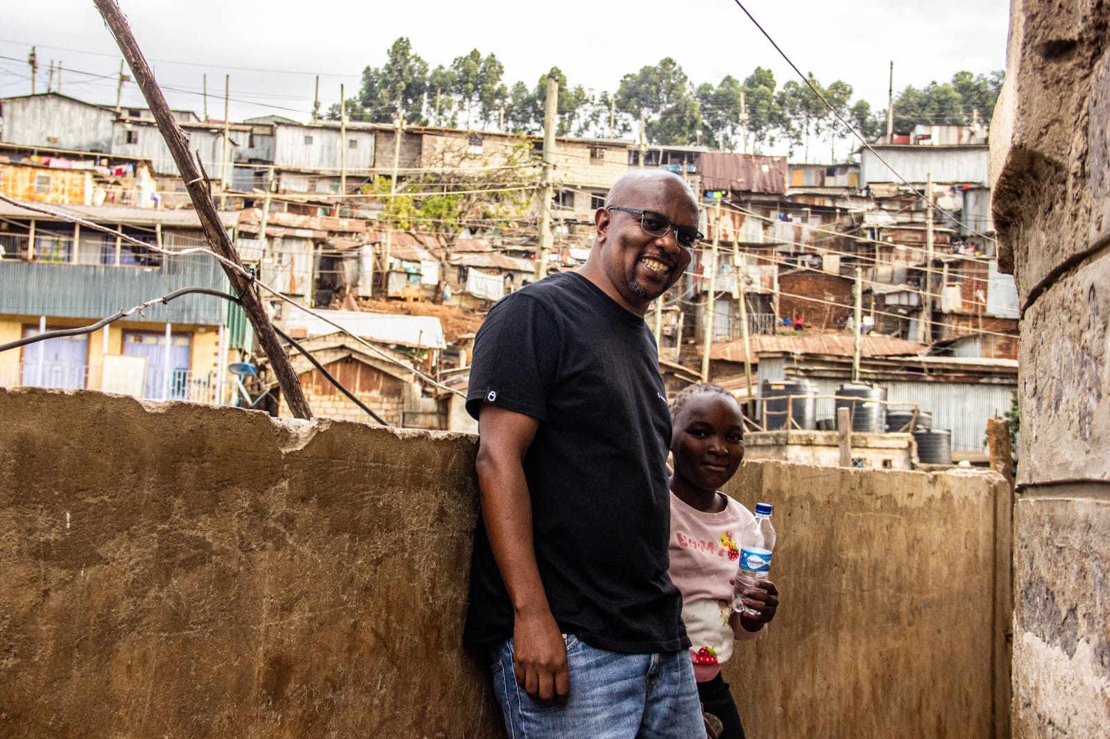 The group standing on a ridge with the rooftops of Kibera stretching behind them